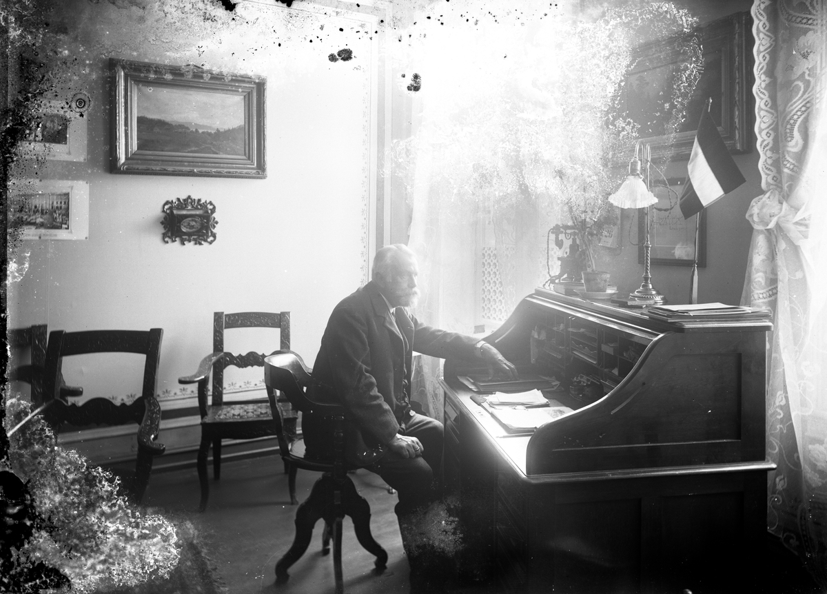 Gustav Borgen, Portrett, mann ved skrivebord i stueinteriør, ukjent sted.