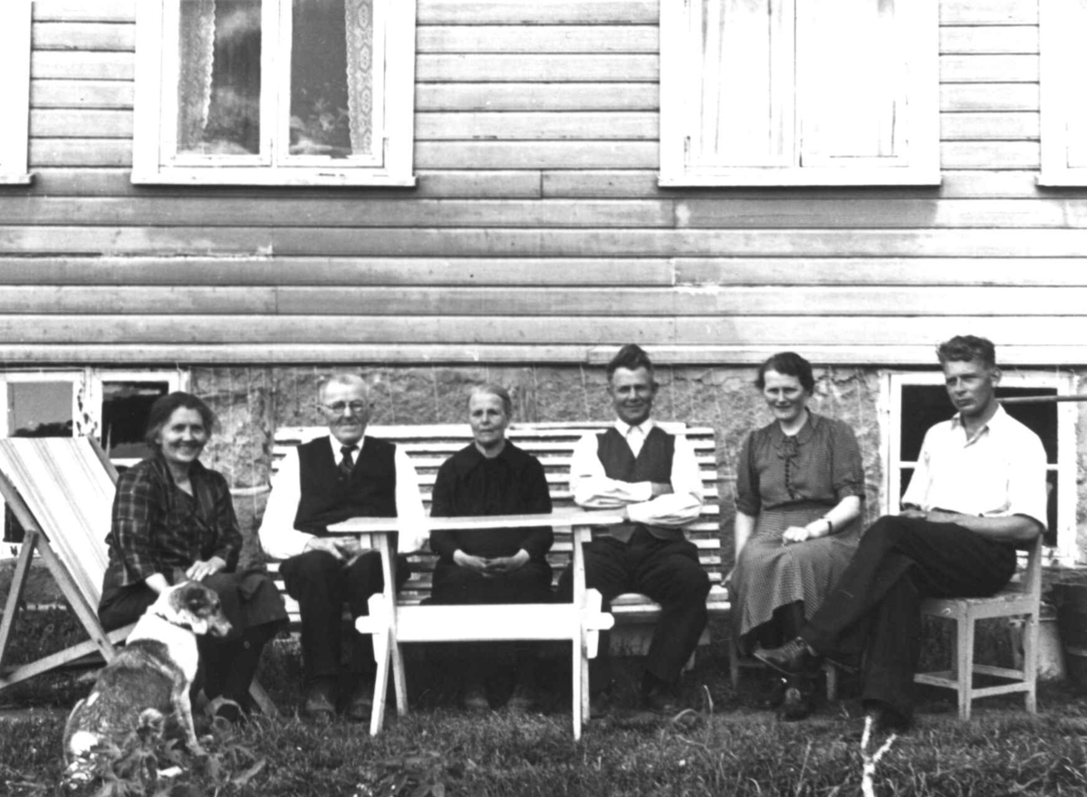 Anna Grostøl, Bernt Eiesland og familie sitter ved hagebordet utenfor huset hans. Fjotland, Kvinesdal 1941.