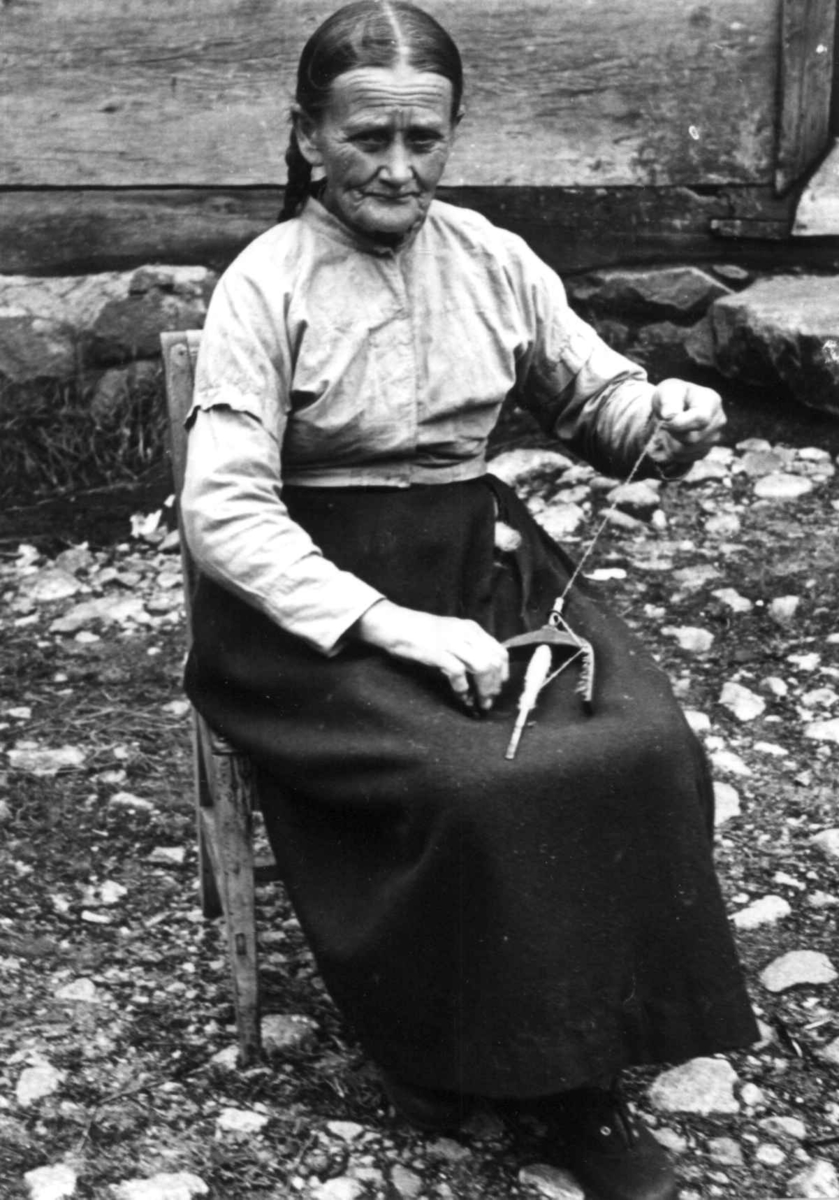 Anna Grostøl, Vinje, Rauland, Telemark 1939. Gro Vå spinner på håndtein.