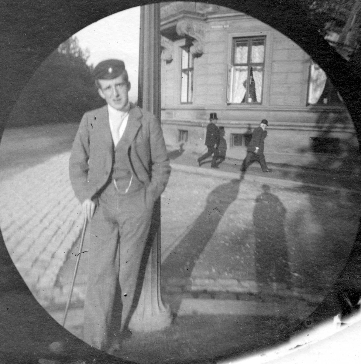 Fredrik Carl Mülertz Størmer, Student Bilten (?) Hiorthdal står lent mot lyktestolpe i gatekryss med bygård bak, Oslo. Student fra 1892.