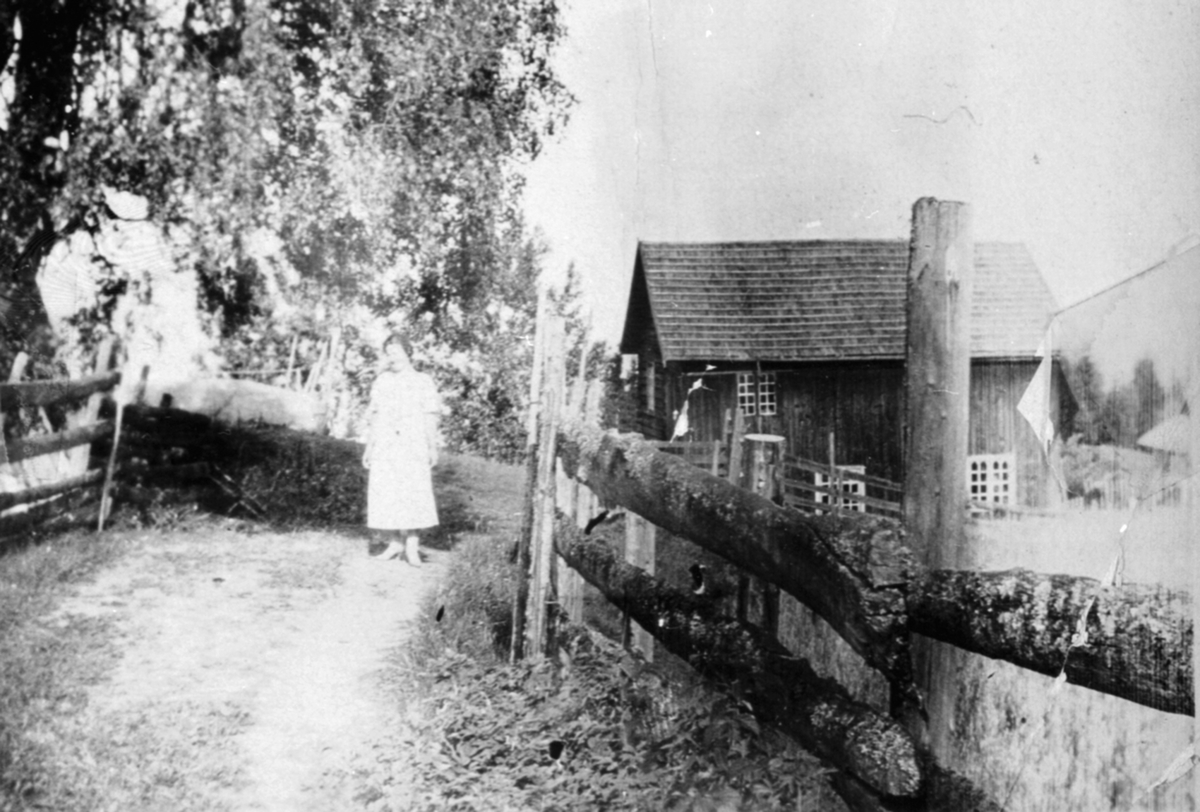Anno Domkirkeodden, Eksteriør. Den eldste bygningen i Granerud, Stavsjø, Hedmark. Revet ca. 1960. Anna Grøtlien f.1909 utenfor huset.