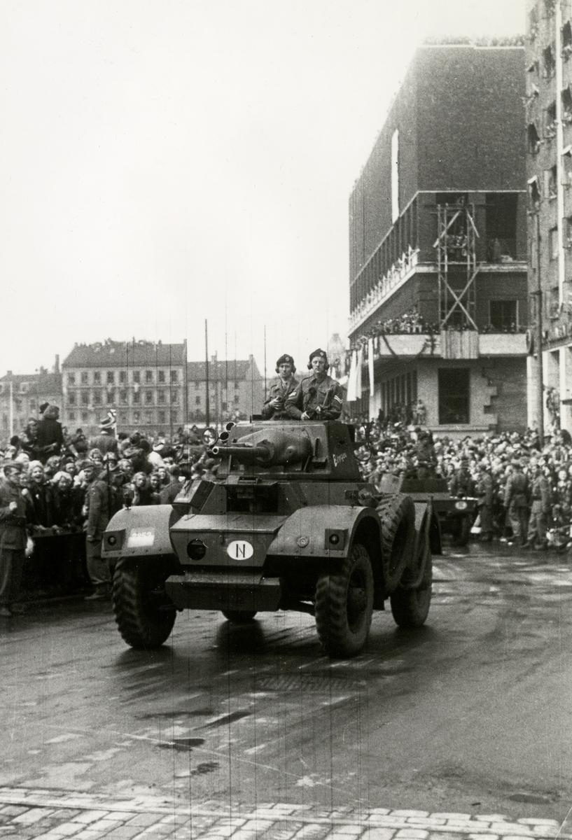 Anders Beer Wilse, Fra Oslo under fredsdagene i 1945. Et militært kjøretøy har akkurat passert Rådhuset. Publikum i bakgrunnen.