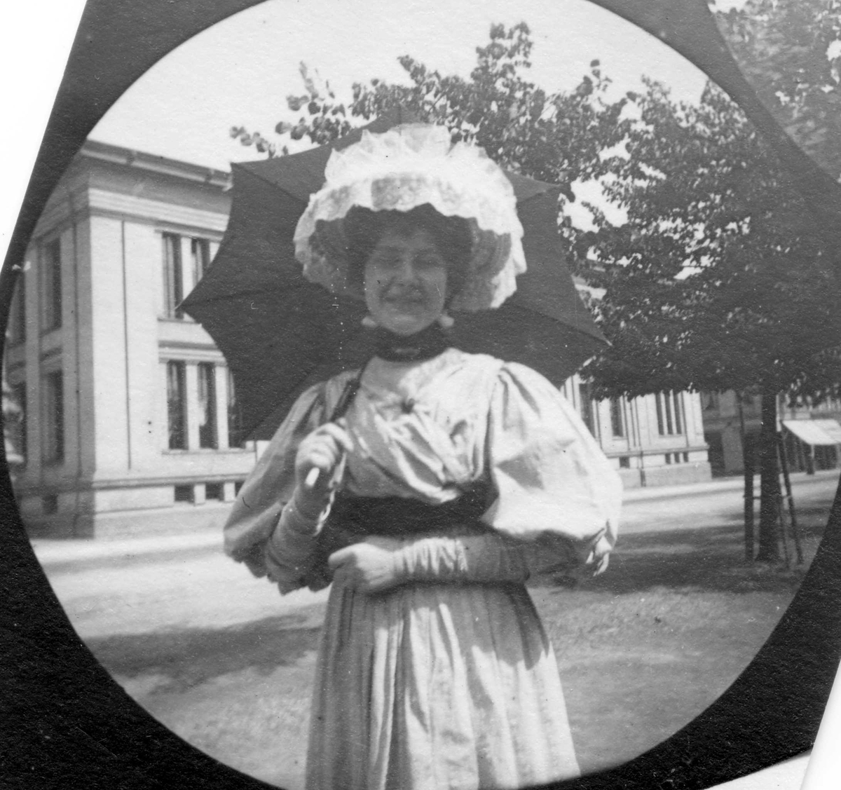 Fredrik Carl Mülertz Størmer, Frk Jotta Pedersen, senere fru Holter, spaserer langs Karl Johans gate, Oslo. Universitetet på andre siden av gata.