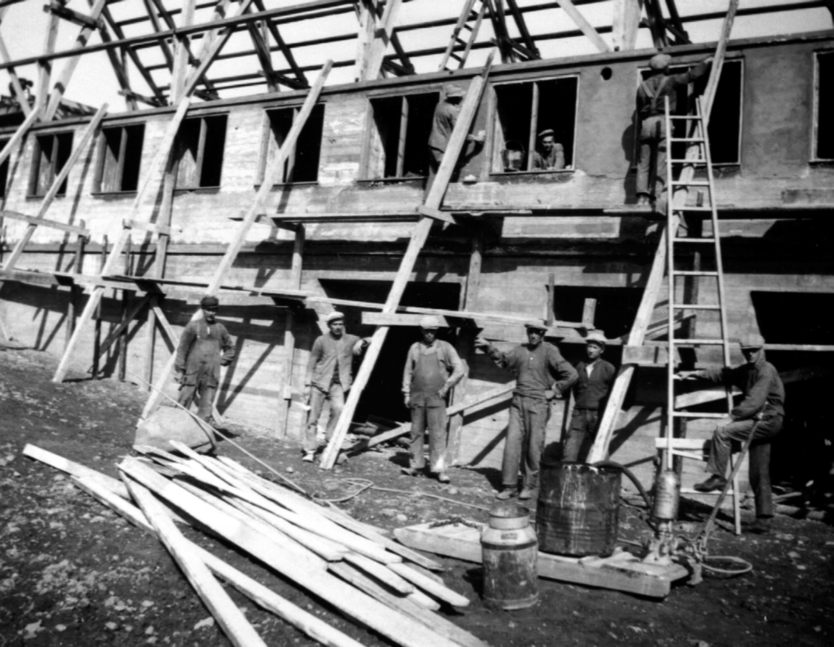 Anno Domkirkeodden, Murerlaget til Johannes Hannestad som bygger opp låven på Hovelsrud, Helgøya etter brannen i 1934. Murere og snekkere. Stående fra venstre: Nr. 1 Johannes Hannestad, nr. 3 Asbjørn Langset, svoger av Johannes og tidligere varaordfører i gamle Nes kommune, nr. 4 muligens Knut Hegge