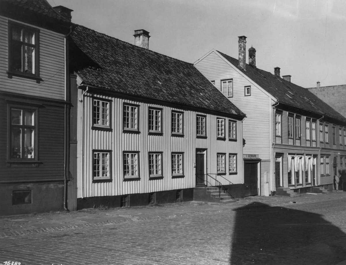 Anders Beer Wilse, Wilse original. Bebyggelse, med en rekke av hus til venstre langs en brosteinsgate.