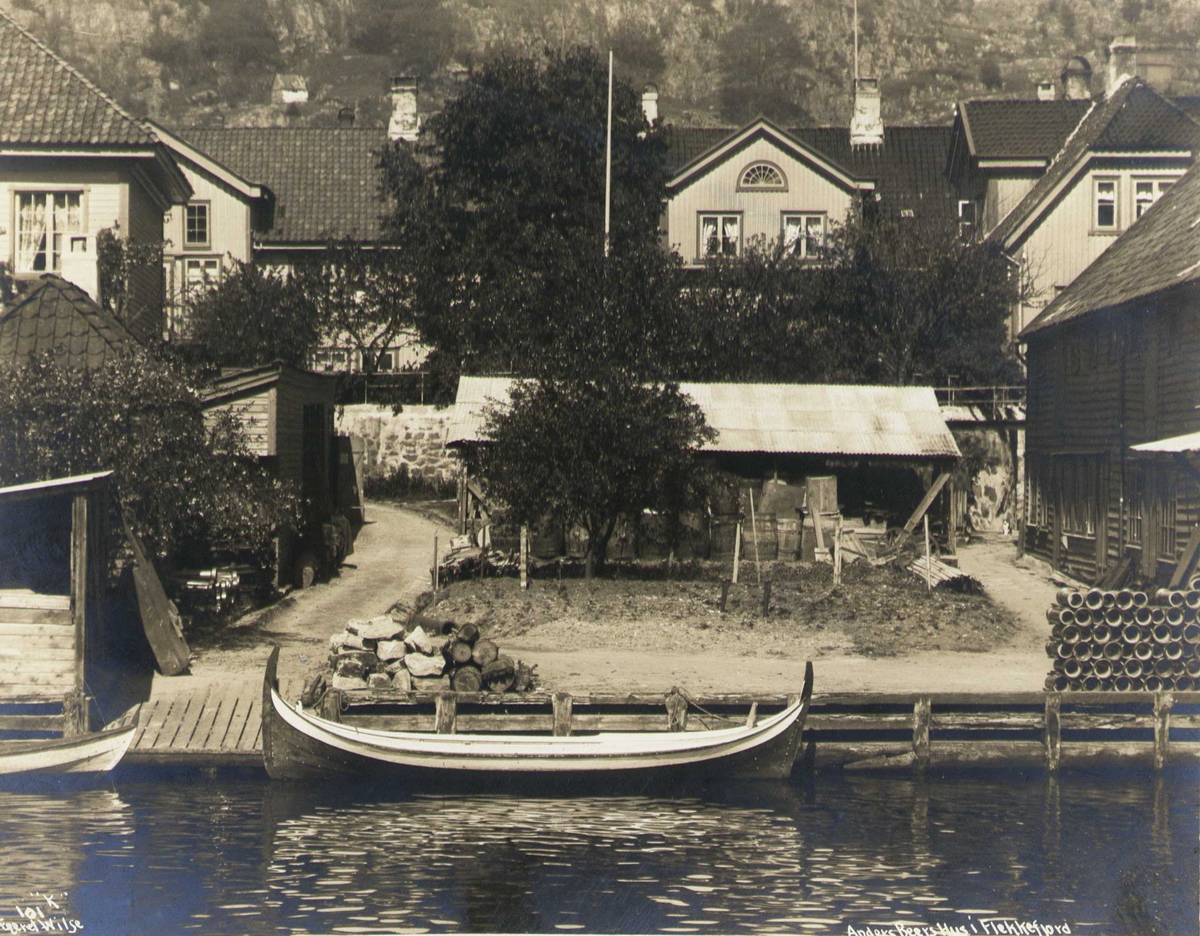Anders Beer Wilse, Anders Beers hus sett fra sjøsiden, Flekkefjord, Vest-Agder. Diverse boder i forgrunnen. Fotografert 1912.