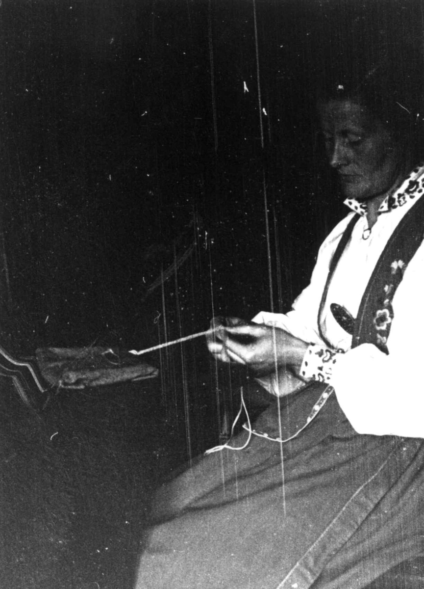Anna Grostøl, Vinje, Telemark 1941. Signe Kåreholmen holder på med telemarksbinding.