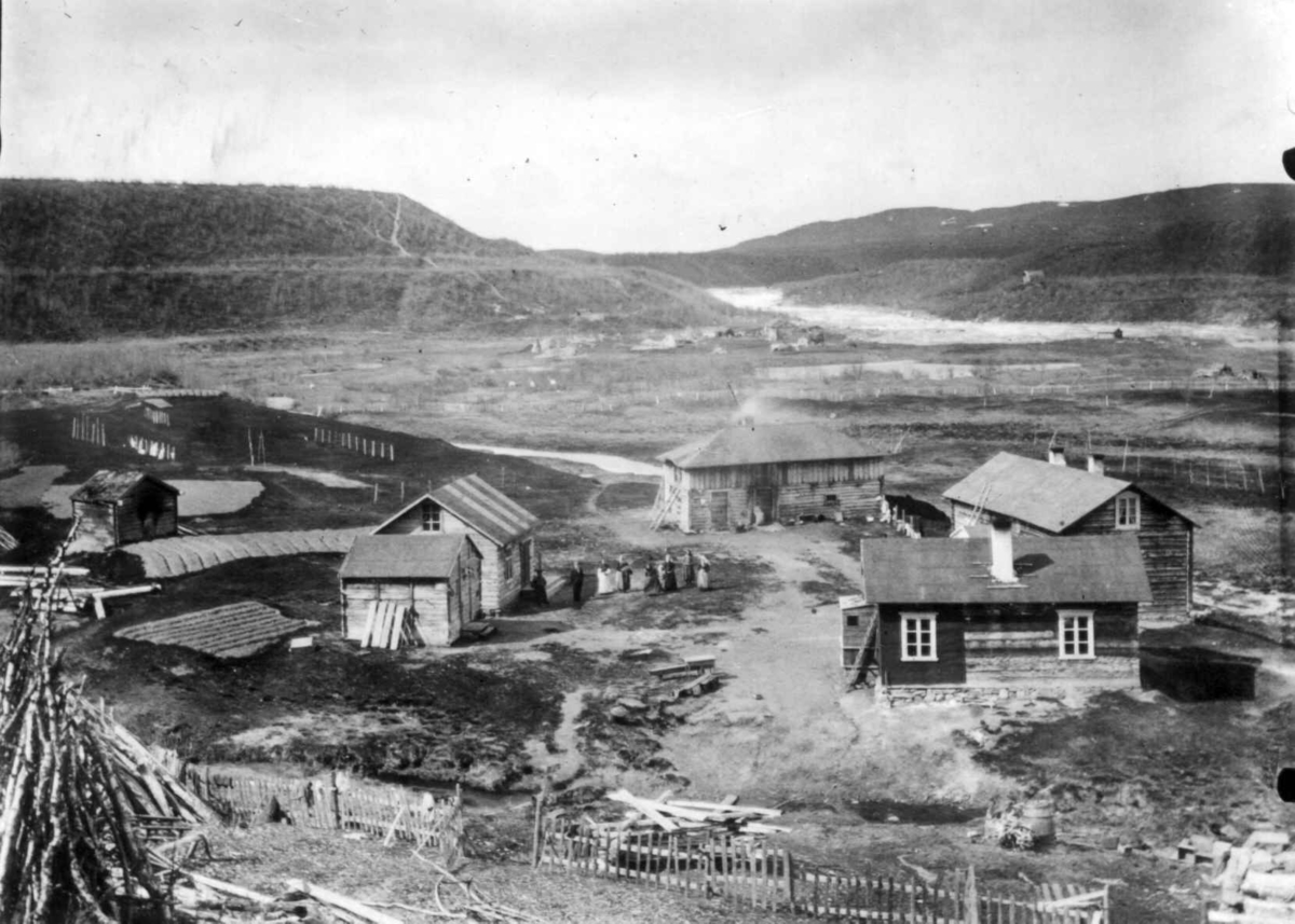 Ellisif Rannveig Wessel, Handelsmann A. Vartiainens gård, Neiden, Sør-Varanger, Finnmark, ca. 1905. I bakgrunnen sees skoltenes plass ved fossen.