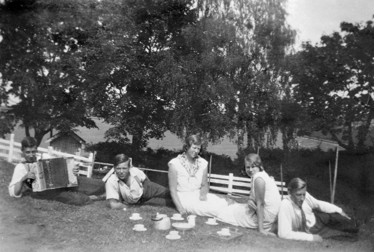 Anno Domkirkeodden, GRUPPE: 5 UNGDOMMER I GRESSET, KAFFESLABRAS, FRA VENSTRE: LIBERG, EINAR MED TREKKSPILL, BUSVOLD, NILS, KORSBAKKEN, ASTRID OG KORSBAKKEN, GUDRUN, UKJENT, STANGE