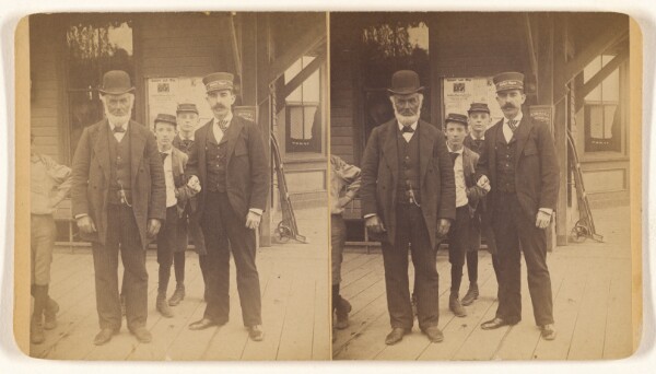 Unknown, [White beared man wearing a derby standing on a platform with a train conductor and three boys]