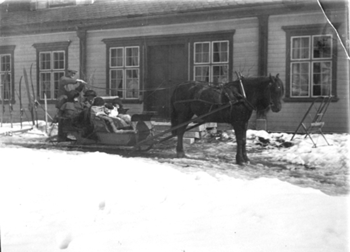 Anno Domkirkeodden, Hestekjøretøy foran hovedbygningen på Grefsheim, Nes, Hedmark med kjørekar, barn og voksne i sleden.