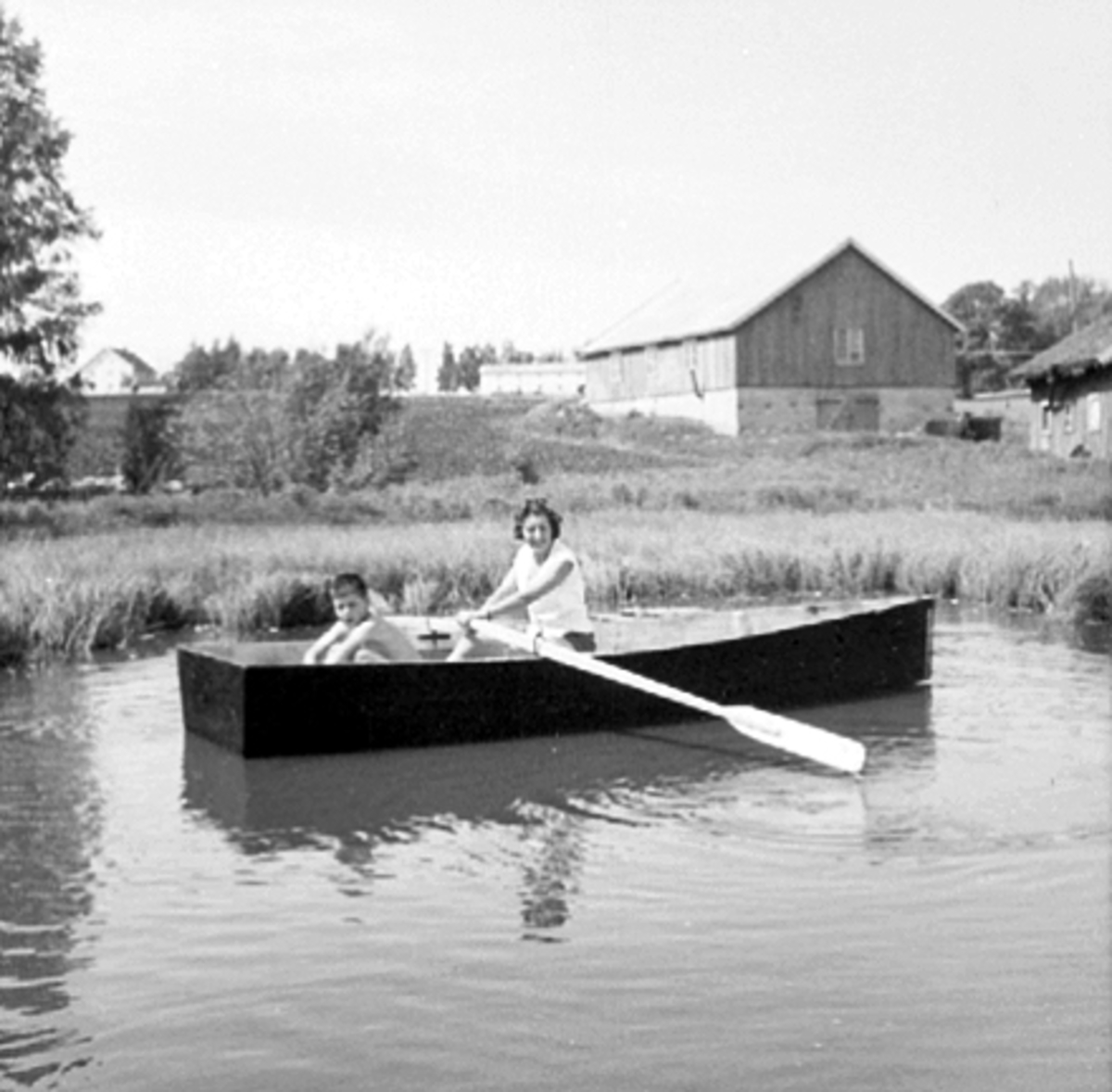 Anno Domkirkeodden, STENBERG NORDRE, OLA OG INGEBORG STENBERG ROR I HJEMMELAGD PRAM I ET TJERN PÅ GARDEN, ROBÅT