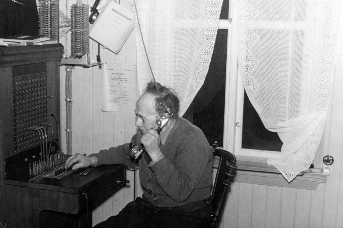Ukjent, Espa telefonsentral, 1953, Syver Løvstad ved sentralbordet. Bildet er tatt siste dagen sentralen var i virksomhet. Flere opplysninger se boka "Handelsteder i Stange" skrevet av Jan Arne Berg, utgitt av Stange Historielag 2012
