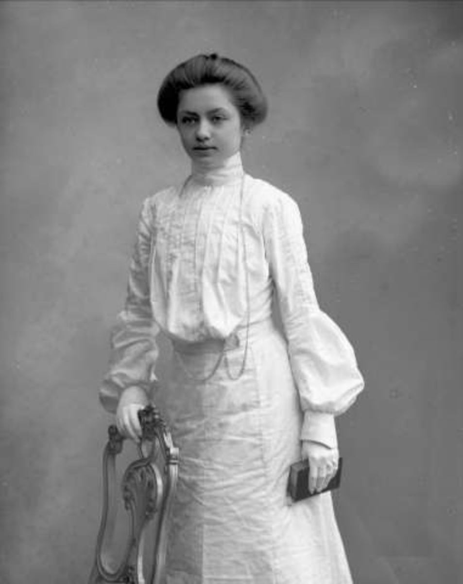 Gustav Borgen, Portrett, ung kvinne i lys drakt ved stol med bok i hånda. Hedvig Andresen.