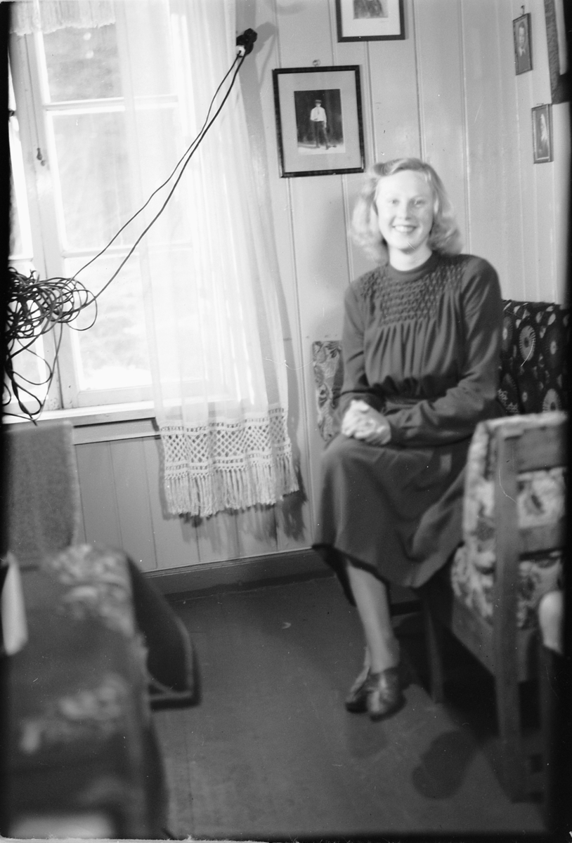 Håkon Prestkværn, Interiør, stue. Ukjent kvinne i en sofa.