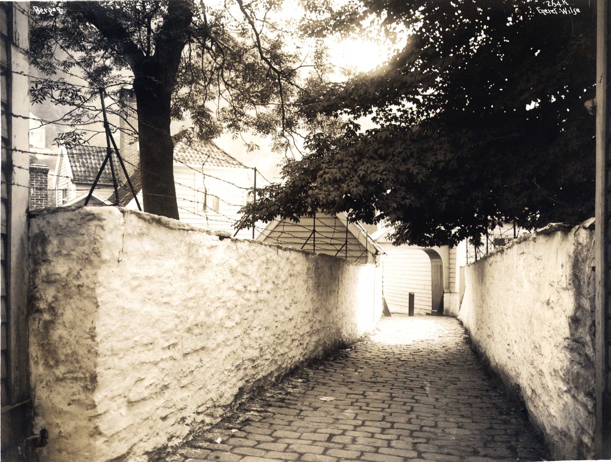 Anders Beer Wilse, Smug med gjennomgang fra Marken til det gamle St. Jørgens Hospital i Kong Oscars gate i Bergen. Fotografert i 1912.