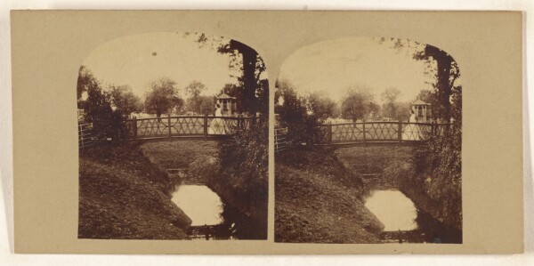 Unknown, [Woman crossing footbridge over stream]