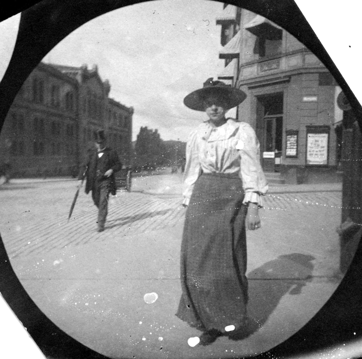 Fredrik Carl Mülertz Størmer, Kvinne spaserer langs Karl Johans gate, Oslo, ved Egertorget, Stortinget i bakgrunnen.