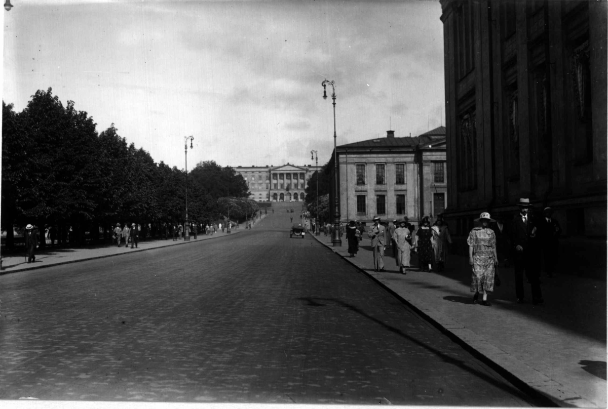 Hermann Christian Neupert, Karl Johans gate mot Slottet, Oslo 1925. Oversiktsbilde. Mennesker spaserer ved Universitetet.