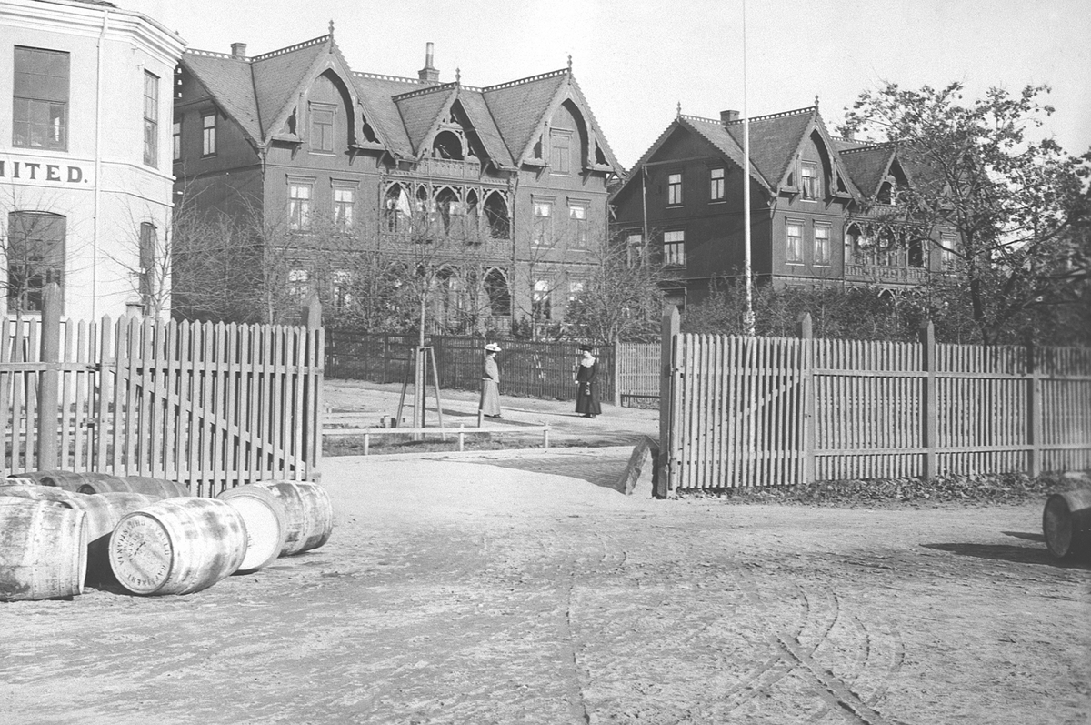 Anno Domkirkeodden, Eksteriør 2 tvillingvillaer, Stangevegen 42-44, bygget i 1890 og revet i 1968. 2 damer, tønner i forgrunnen, Vølund.