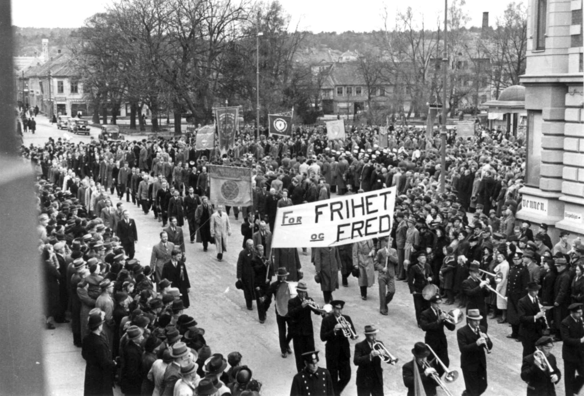Anna Grostøl, 1. maitoget kommer ut fra torget i Kristiansand 1939. Den første parolen i toget er "For FRIHET og FRED".
