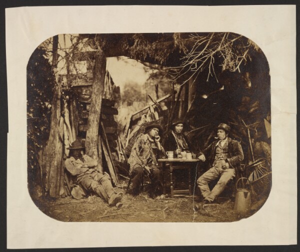 Unknown, [Men resting around table in a clearing]