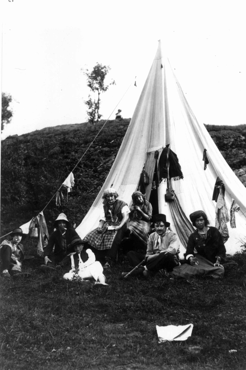 Hermann Christian Neupert, Hovedøya, Oslo. 1910. Sommermotiv. Fest. Kvinner og menn utenfor et telt. Klær til tørk.