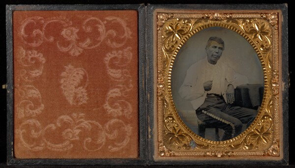 Unknown, [Portrait of a Man in a White Jacket Seated at a Table]