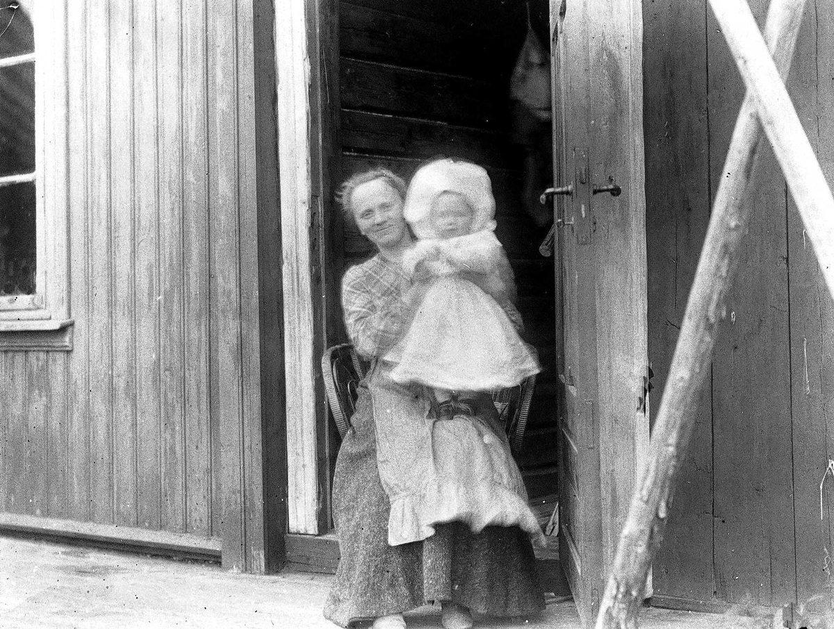 Axel Quinsgaard Wiborg, Familiemedlemmer på Holoa seter, Hadeland, Jevnaker, Oppland, 1903. Margrethe med Halvor Nicolai, begge Q. Wiborg, mor og barn i døråpning.