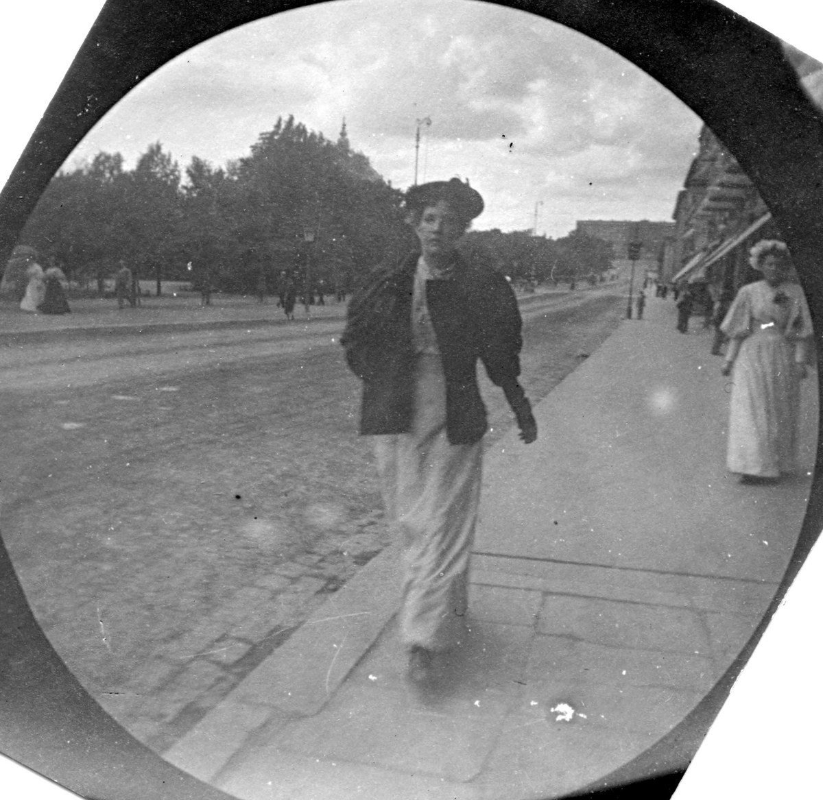 Fredrik Carl Mülertz Størmer, Kvinne spaserer langs Karl Johans gate, Oslo.. Slottet skimtes..