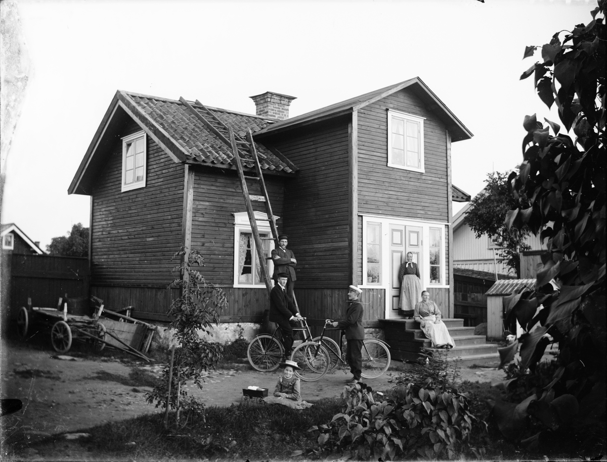 Skötsner-Edhlund, Män, kvinnor och barn framför bostadshus, Östhammar, Uppland