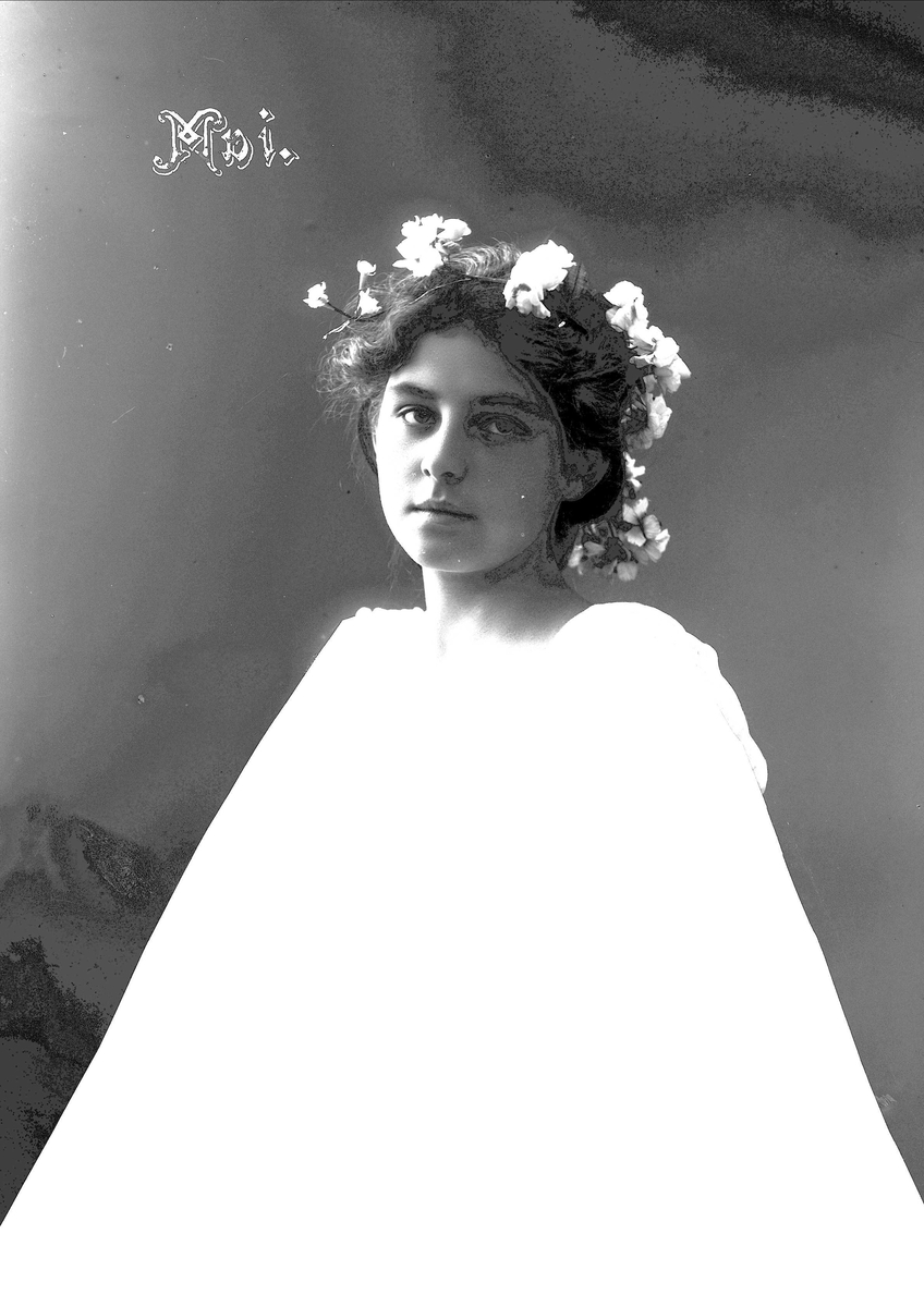Solveig Lund, Studioportrett av kvinne i drakt med blomster i håret.