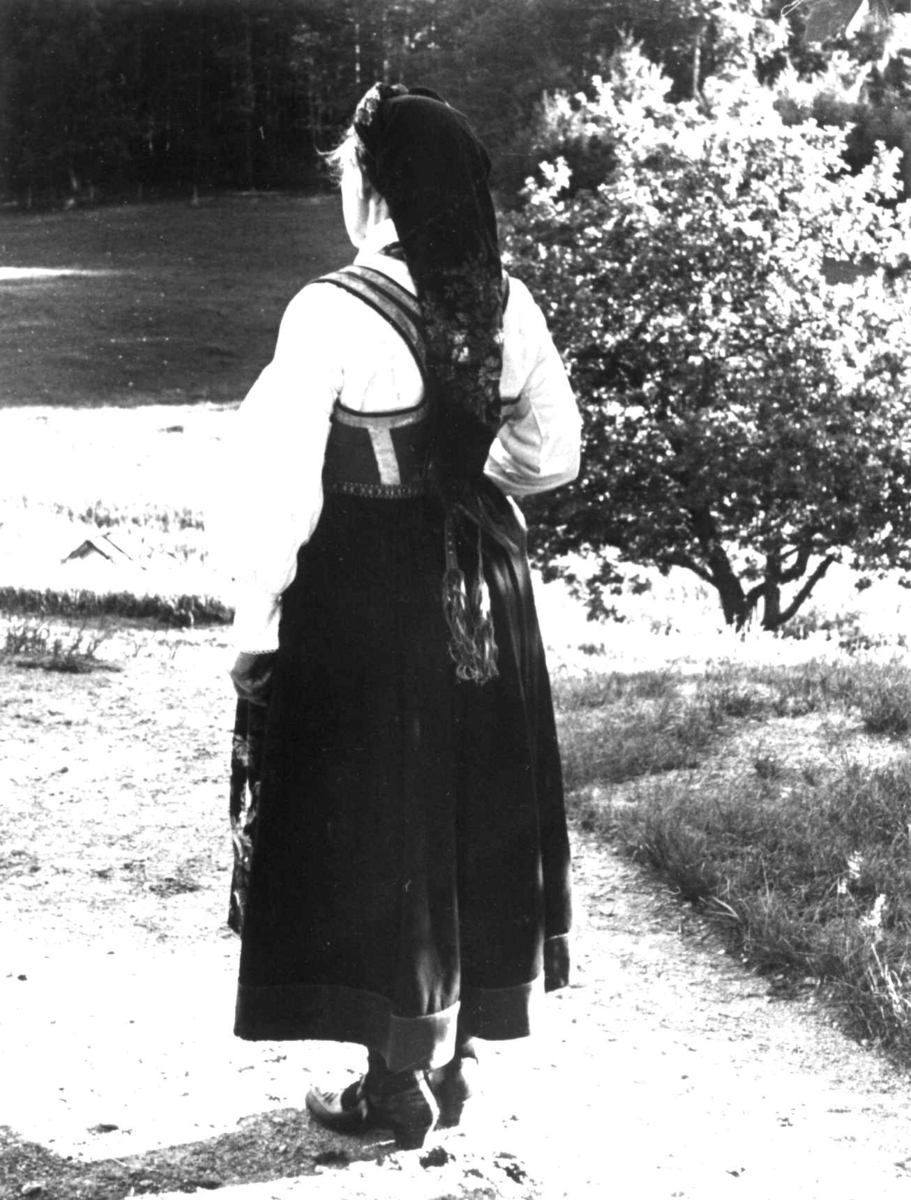 Anna Grostøl, Dølemo Åmli, Aust-Agder 1940. Åmli, Fru Guro Eppeland kledd i kvinnedrakt sett bakfra.