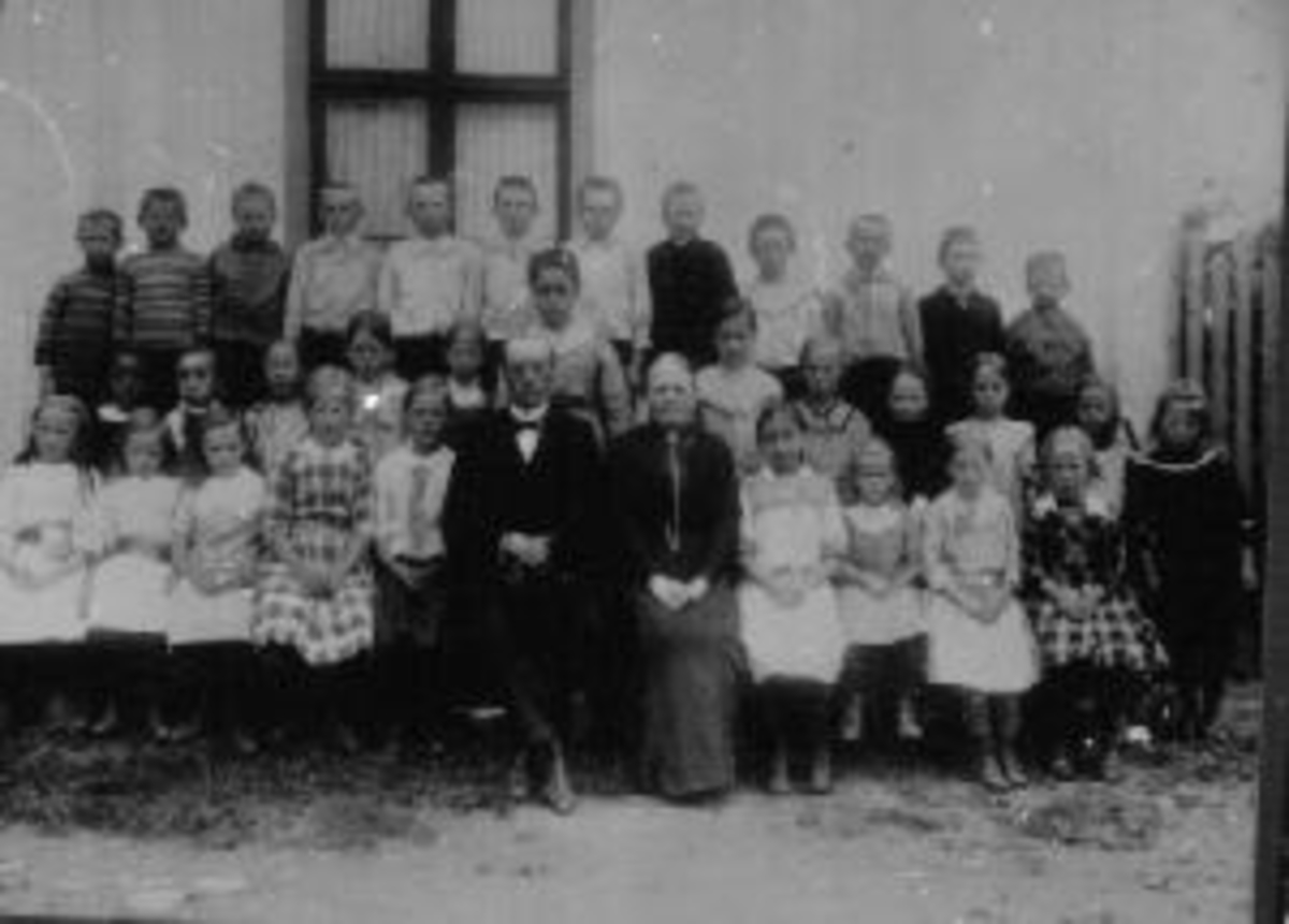 Anno Domkirkeodden, Stor gruppe skoleelever oppstillt utenfor Kirkekretsen skole, Veldre, Ringsaker. Lærere er Oline Rud og Johan Aarskog.