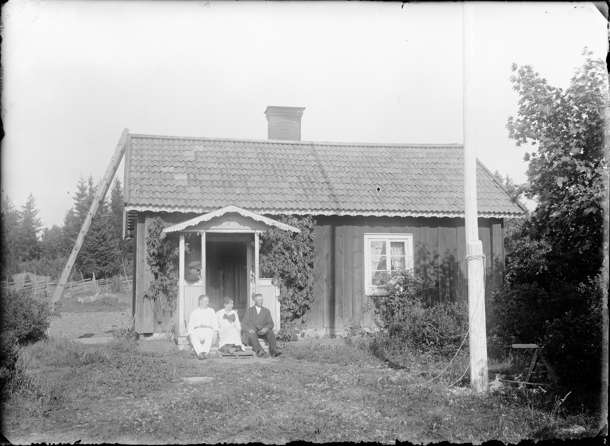 Skötsner-Edhlund, Män och kvinna utanför bostadshus, Östhammar, Uppland