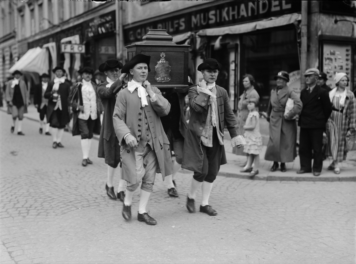 Paul Sandberg, "Hantverkstågets mästare och gesäller i tidstrogen kostymering utgjorde ett pittoreskt inslag i festligheterna" när Upsala Fabriks- och handtverksförenings utställning invigdes, Stora torget
