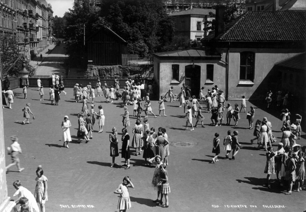Hermann Christian Neupert, Ruseløkka skole, Oslo. 1932. Skolegård. Frikvarter. Skolebarn. Lærerinner. Bygate i bakgrunnen.