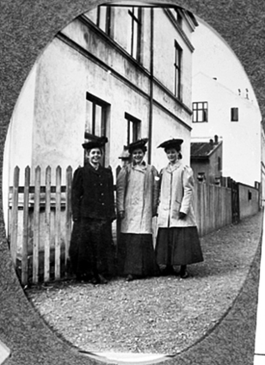 Anno Domkirkeodden, GRUPPE 3 UNGE DAMER MED HATT OG YTTERTØY FORAN SKOLEGATA 12
