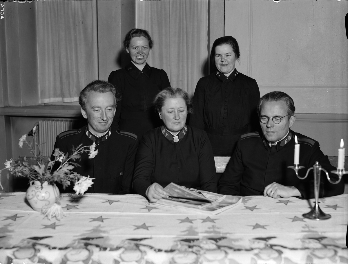 Paul Sandberg, Kårchefen major Nils Slåtte, slumstationens föreståndarinna, major Berta Norlander och divisionschefen brigadör David Eriksson. Bakom dem står kapten Valborg Bengtsson och adjutant Vivi Lundqvist - på Frälsningsarméns adventfest med utdelning av presentkort till "barnrika familjer och åldringar i s…