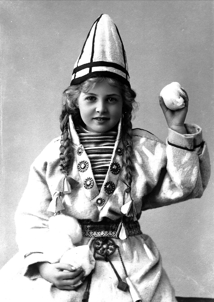 Solveig Lund, Pike i sameliknende drakt med kofte, lue og belte. I hendene holder hun jukse snøballer.