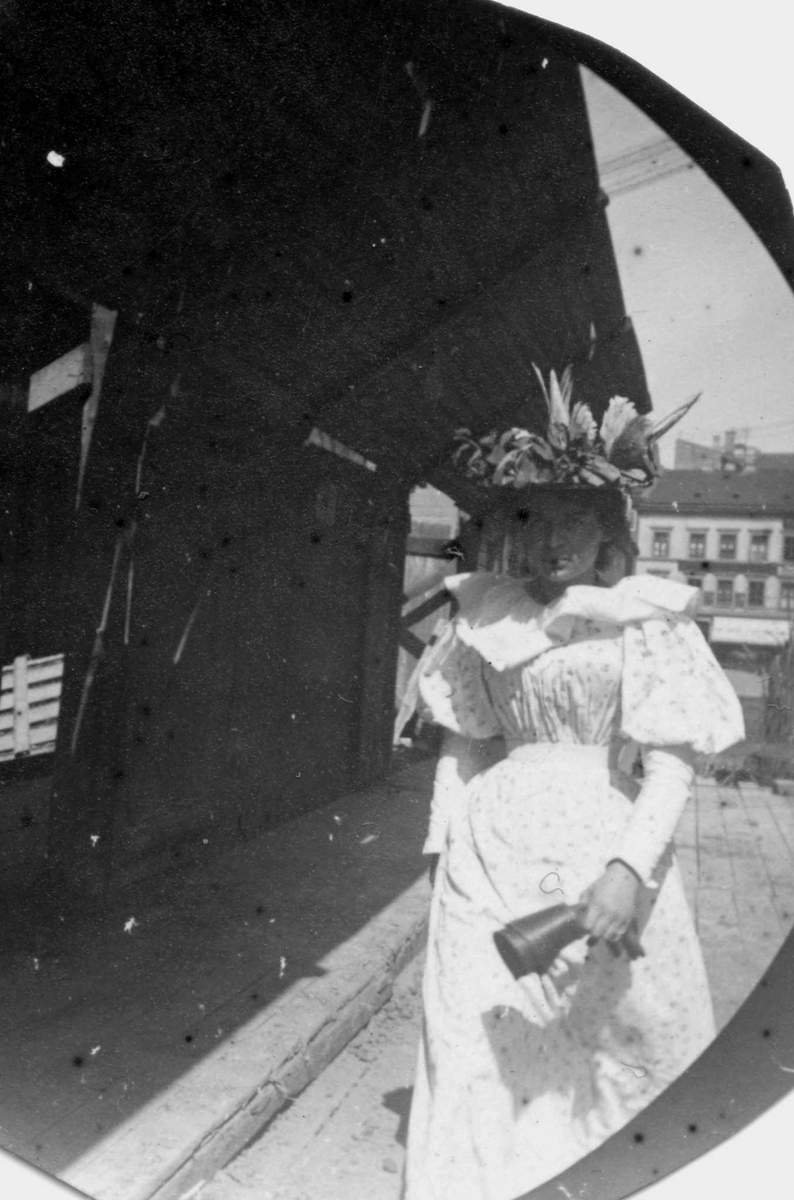 Fredrik Carl Mülertz Størmer, Hvitkledd kvinne spaserer langs en slags verkstedsbygning, ant. Oslo, Bygårder i bakgrunnen.