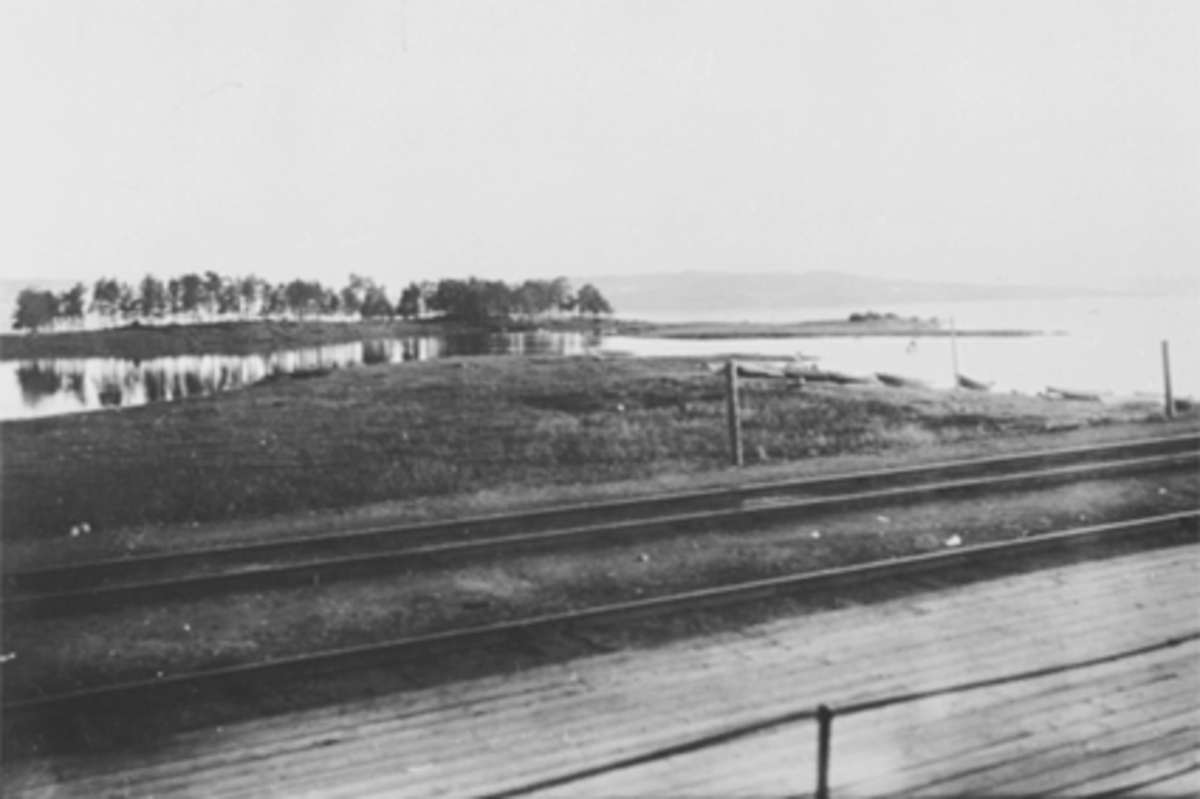 Anno Domkirkeodden, Tjuvholmen mot Helgøya. Båter på stranda. Jernbanespor.