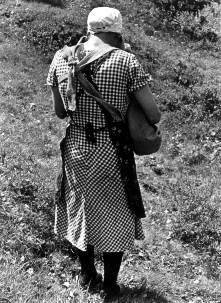 Anna Grostøl, Ingeborg bærer et barn i linde på Engedal. Fjotland, Kvinesdal 1941.
