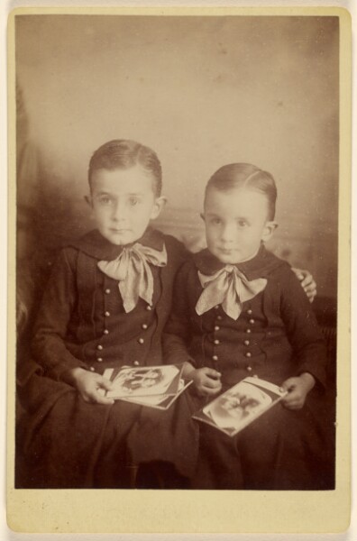 Unknown, [Two boys seated, holding some cabinet cards]