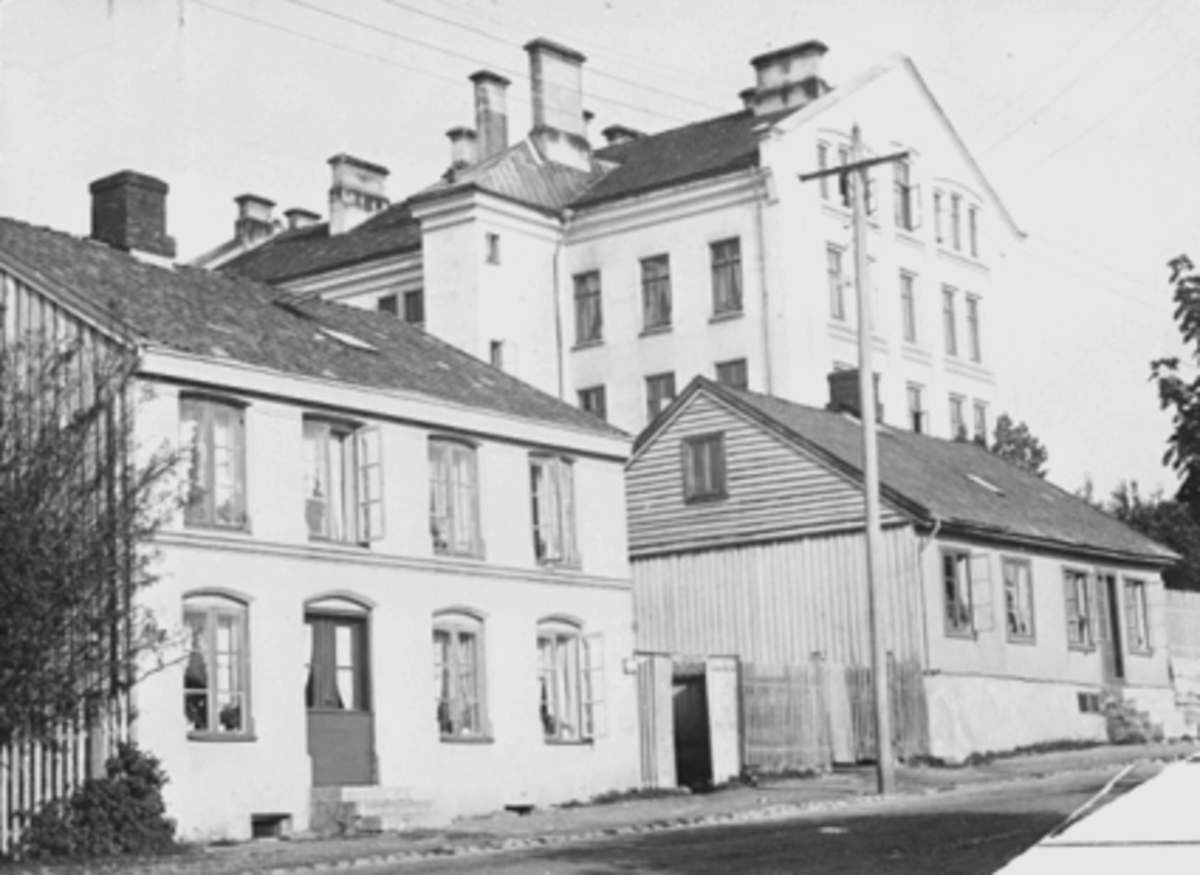 Anno Domkirkeodden, EKSTERIØR, STORHAMARGATA 43, HAMAR KATEDRALSKOLE. Tv murmester Erik Røhne sin gård fra 1864, th Lars Olsen sin gård fra 1860-61.