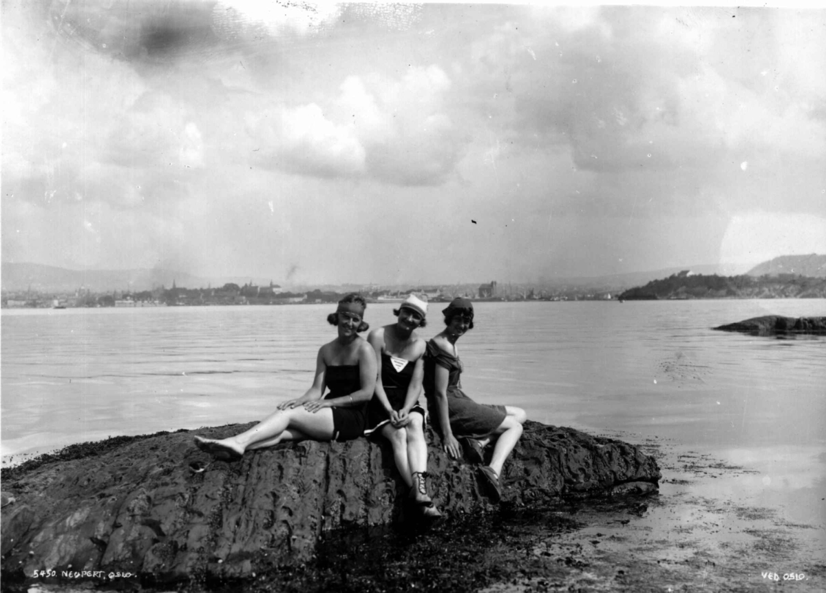 Hermann Christian Neupert, Oslo. Tre kvinner i badedrakt på et svaberg i Oslofjorden. 1927. Øyene og byen i bakgrunnen.