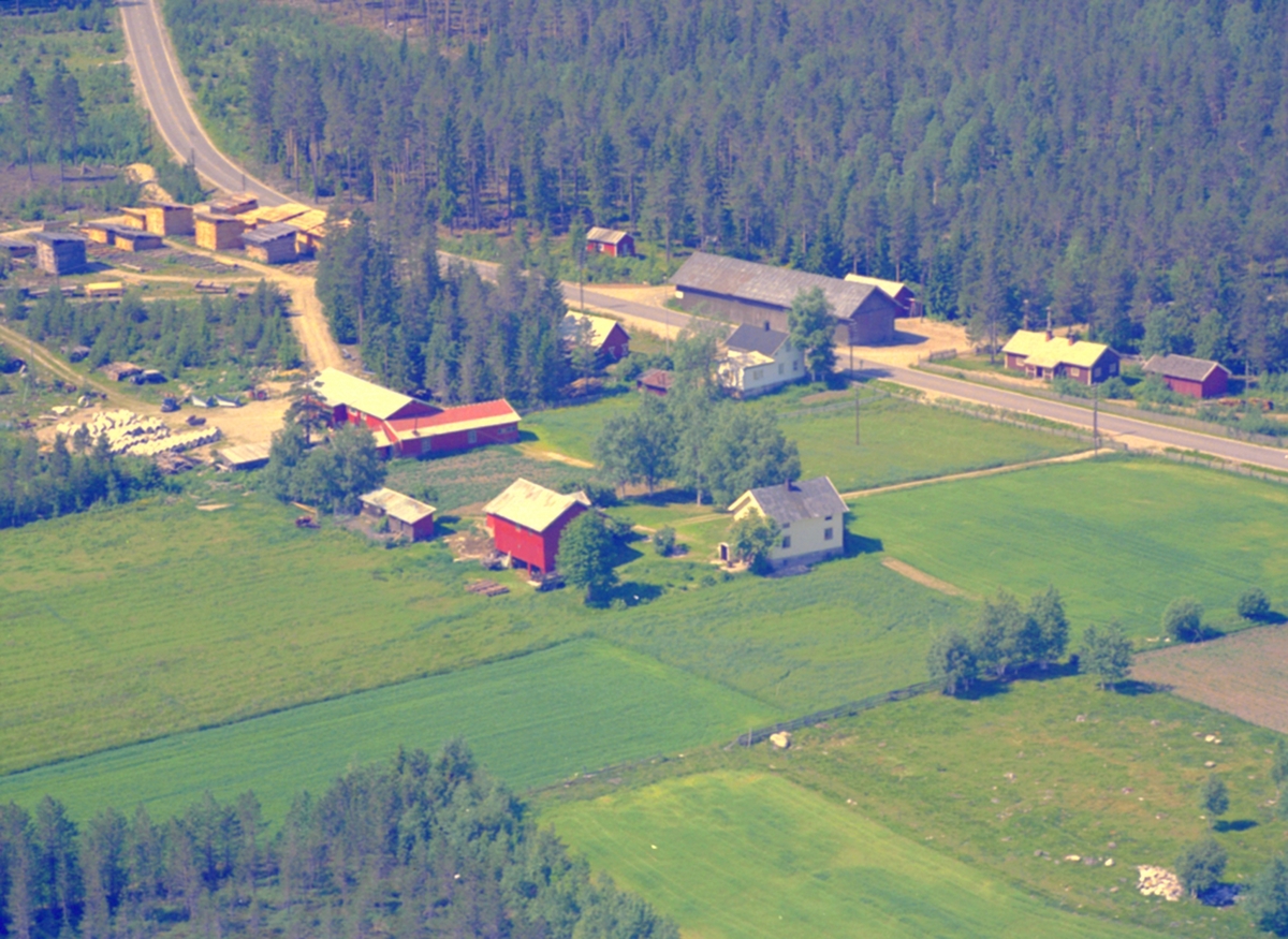 Widerøes Flyveselskap A/S, FLYFOTO. LØTEN. SAGBRUK. Riksvei 25 (Chauseen) ved Ebru. Veien til Nordbygda og veien til fjellet tar av på hver sin side av det grå, lange huset midt i bildet.