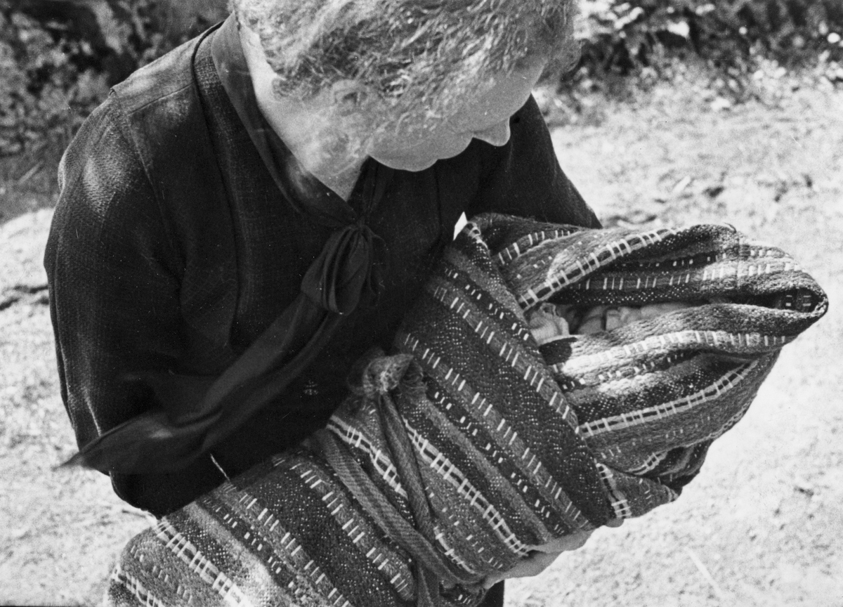 Anna Grostøl, Barn bæres i linde til dåp. Fjotland, Kvinesdal, Vest-Agder 1941.
