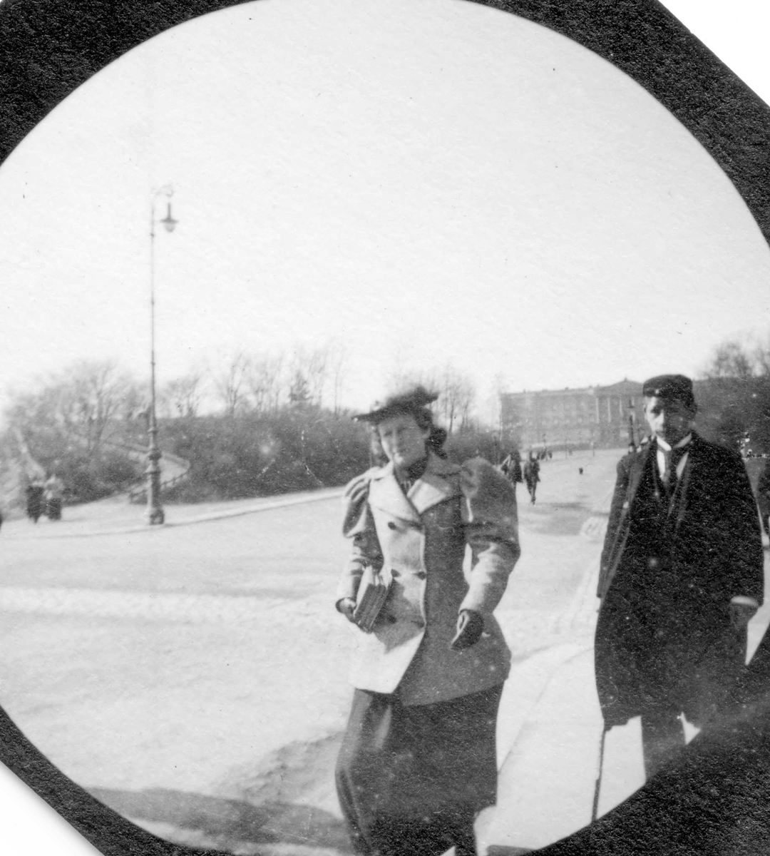 Fredrik Carl Mülertz Størmer, Frk. Sommerville og student Bonnevie spaserer langs Karl Johans gate, Oslo, med Slottet i ryggen.