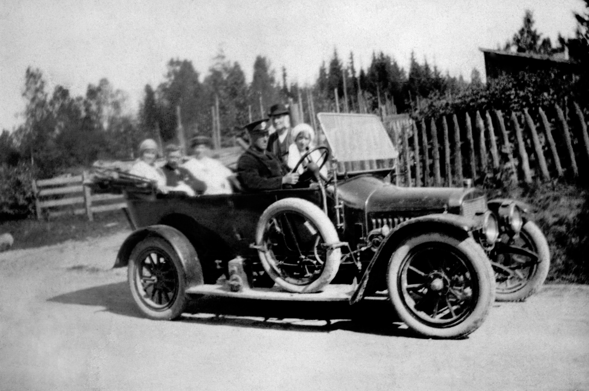 Anno Domkirkeodden, På biltur til Hamar sommeren 1916, sommeren 1916 i Lyksetvegen, bilen er en Adler. Arne Kvarstad, Nora og Gunnar Fredheim, Oline Fredheim, Simen Fredheim, ukjent. Ut fra førerens uniform kan man anta at dette er en drosjebil.